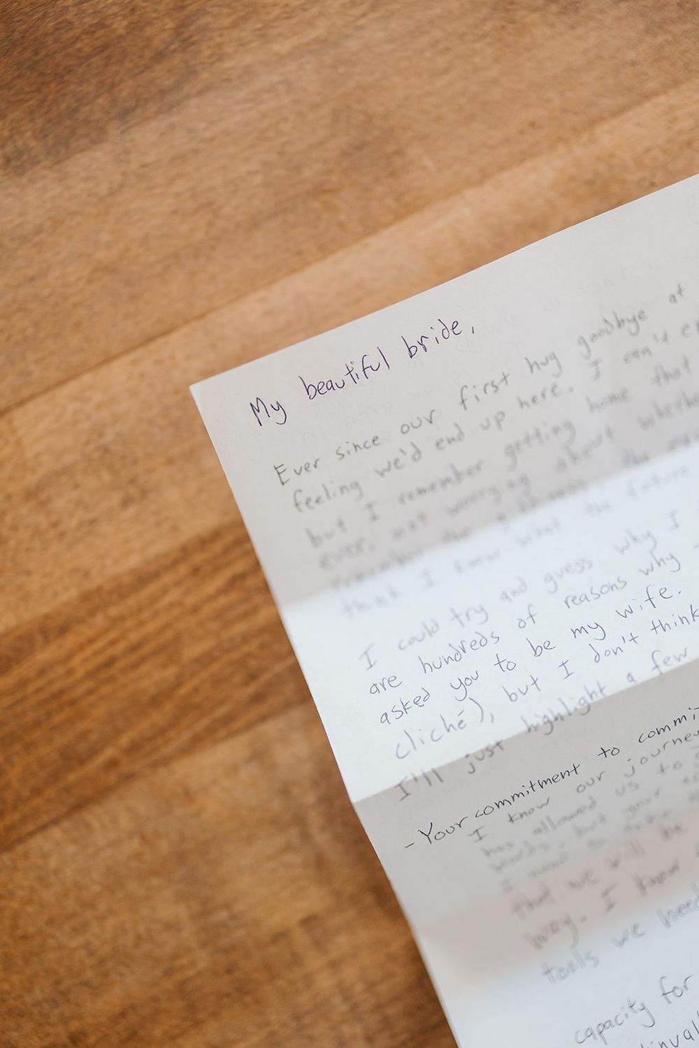 A handwritten letter beginning with 'My beautiful bride' rests on a wooden surface.