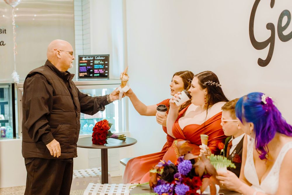 A celebratory scene shows people in formal attire giving high fives at what appears to be a wedding venue.