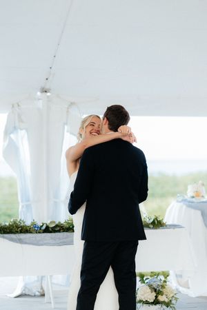 A sequence of tender moments captured under a white wedding tent with soft lighting and floral decorations.
