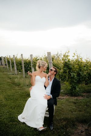 A romantic moment between a couple in a vineyard at sunset, with rows of grape vines in the background.