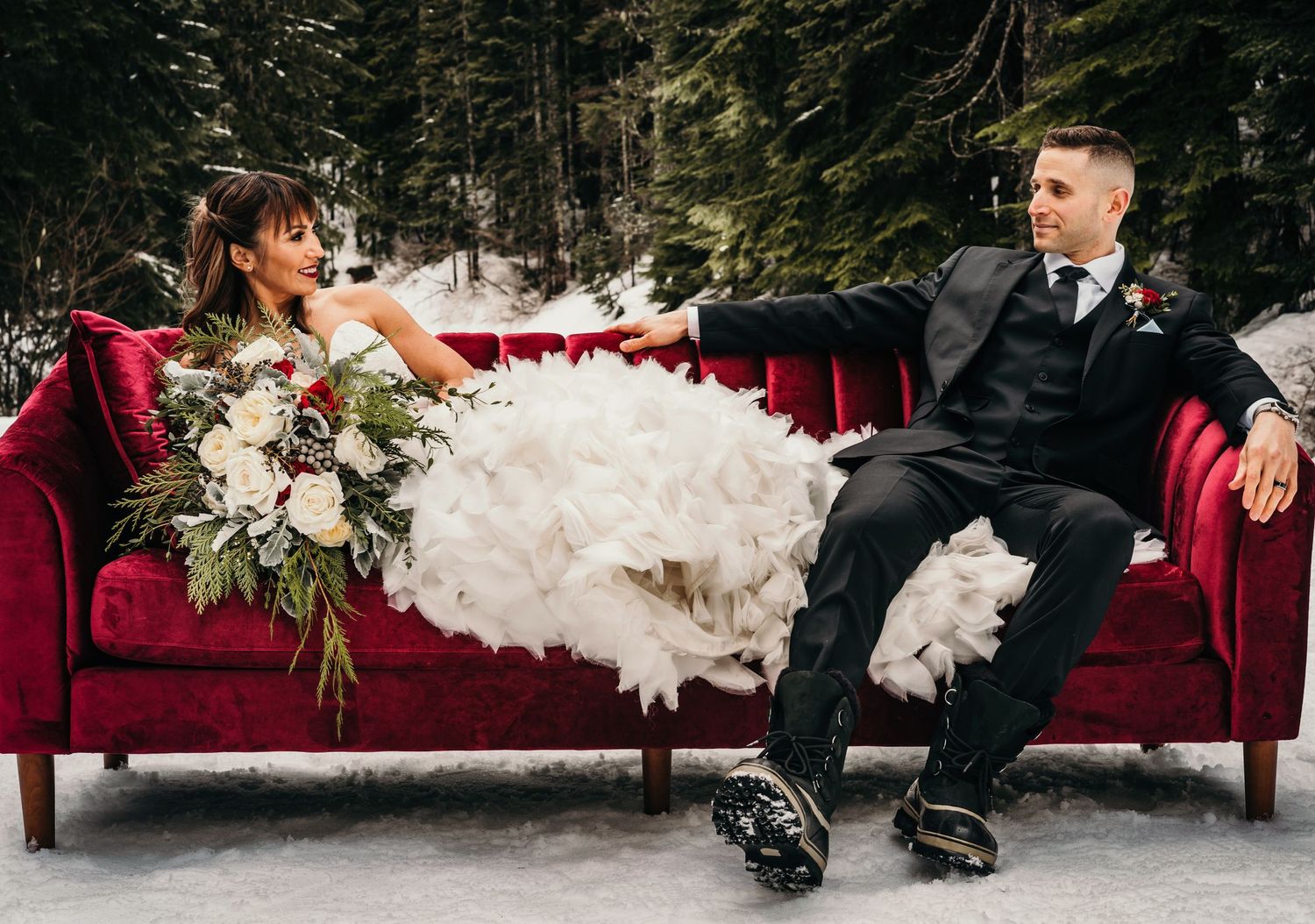 elopment photography of husband and wife in wedding attire sitting on red couch at Gold Creek Pond after they eloped.
