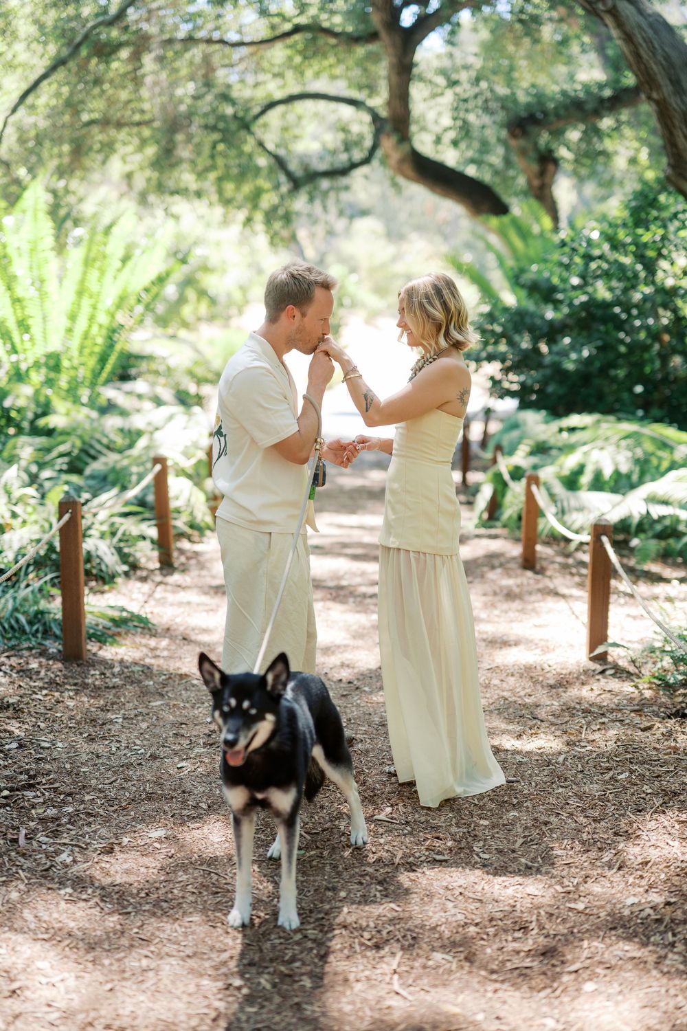 A joyful moment shared on a woodland path with their loyal husky companion standing guard.