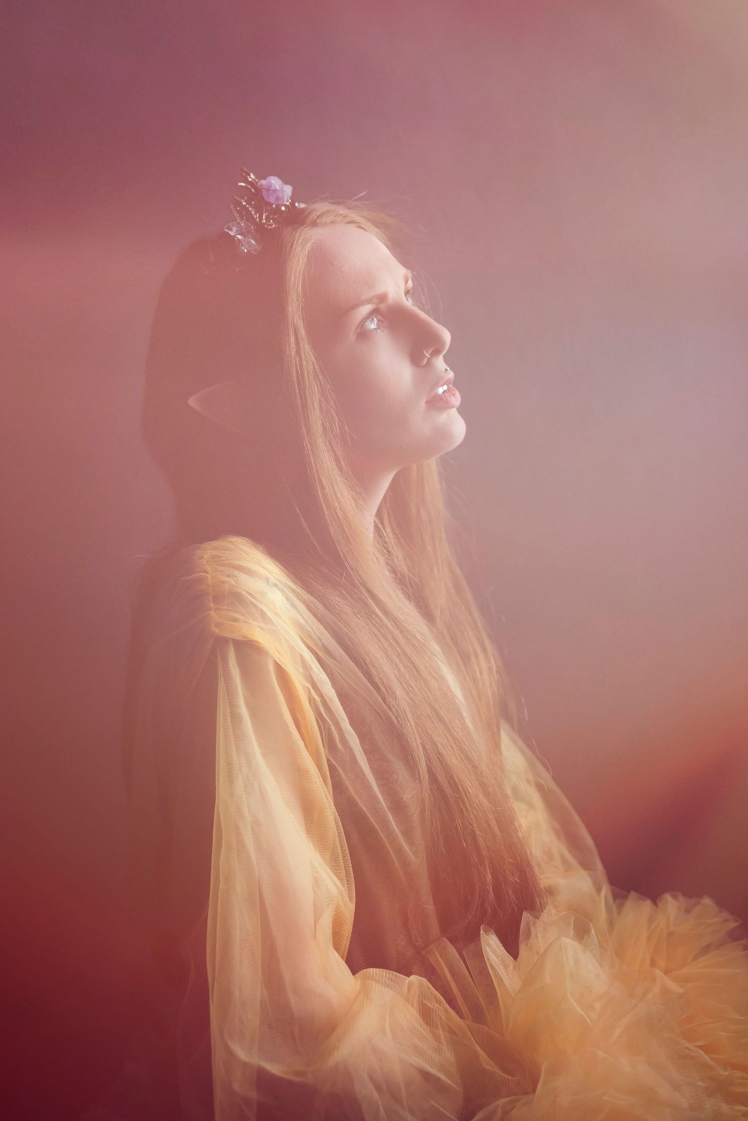 Dreamy ethereal portrait series showing a figure in warm lighting with flowing blonde hair and gold tulle fabric.