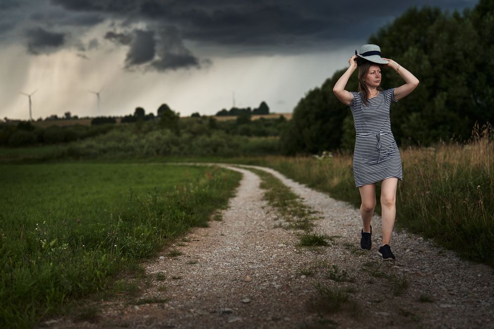 styled photoshoot, stormy sky, moody outdoor portrait, countryside shoot, natural light, dramatic weather, editorial style