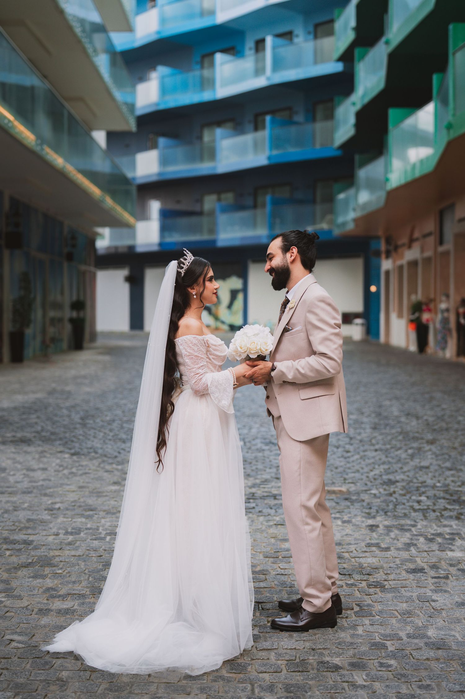 A bride and groom share a romantic moment on cobblestone streets in an intimate wedding photoshoot series.