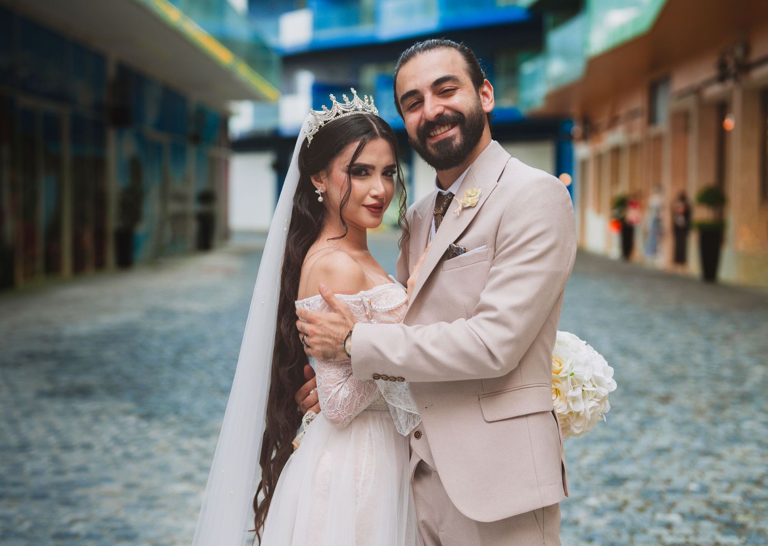 A couple shares a romantic moment on a cobblestone street during a wedding photo session.