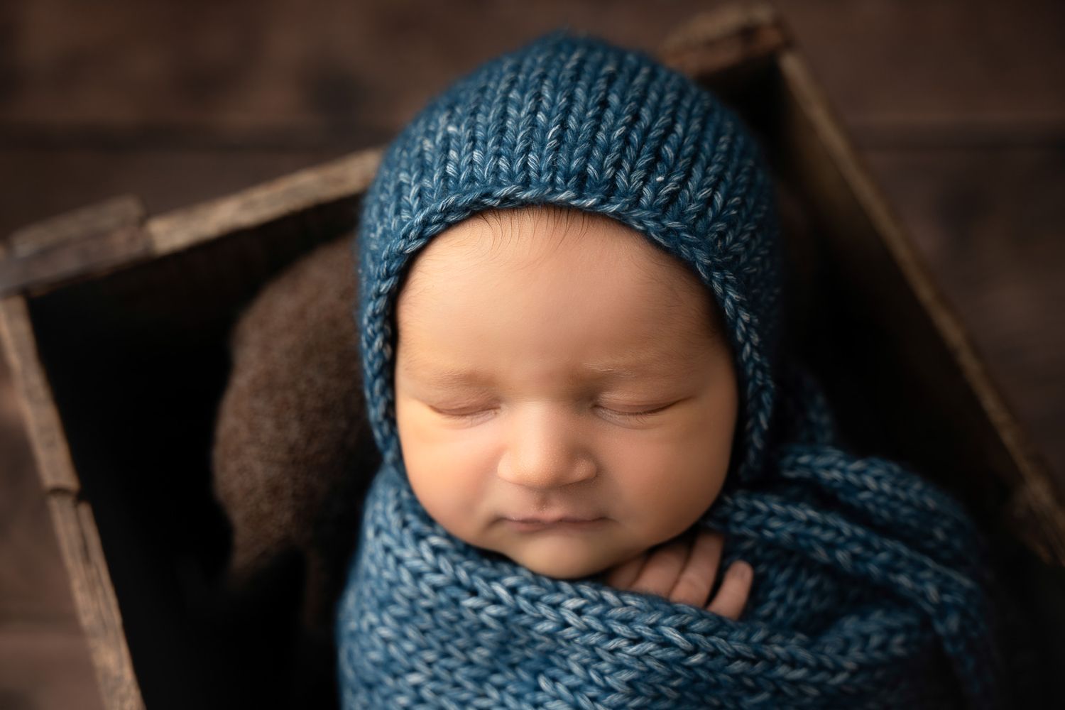 Small child wearing a cozy dark teal knit hat and scarf snuggles in a close-up series of images.