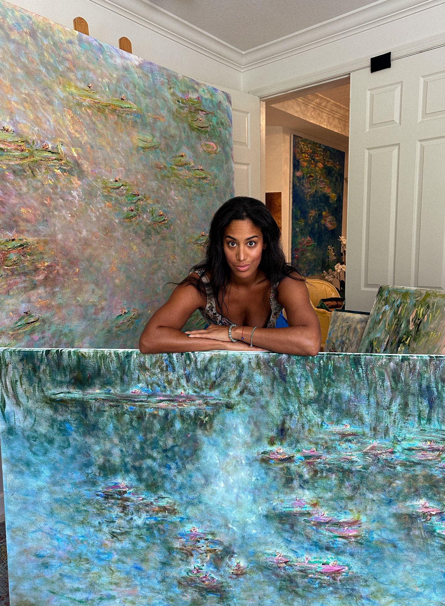 Vibrant painting of water lilies on a pond surrounded by drooping willow branches in rich greens and blues. Monet Kim ahonoukoun  legacy