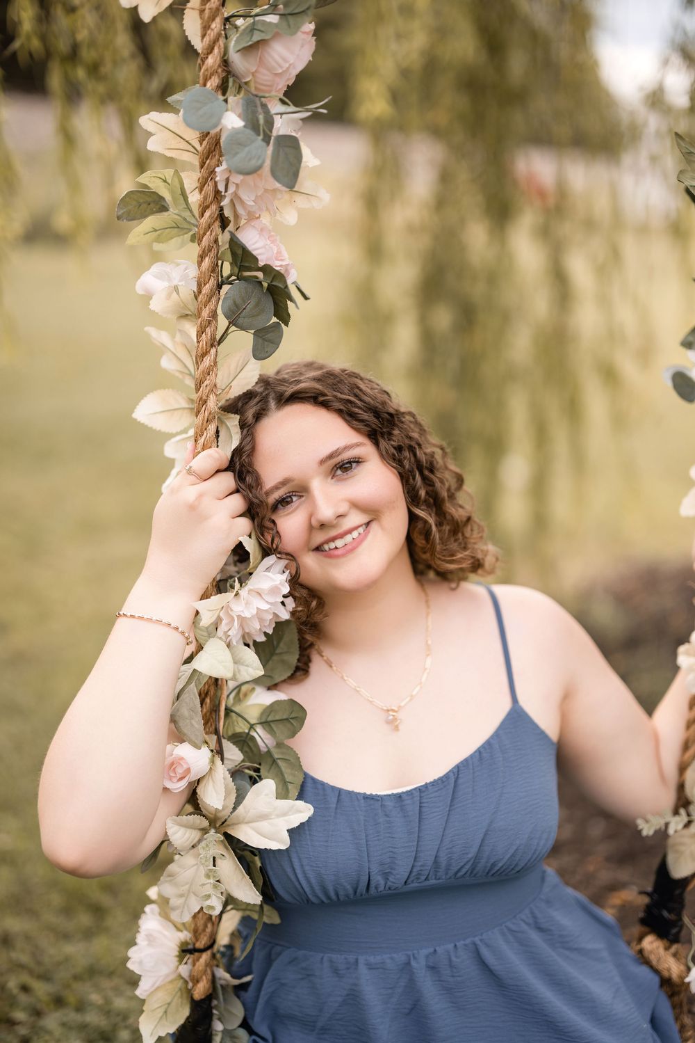Floral garden scene with decorative vine adorned with white roses and eucalyptus leaves against a soft blurred background.