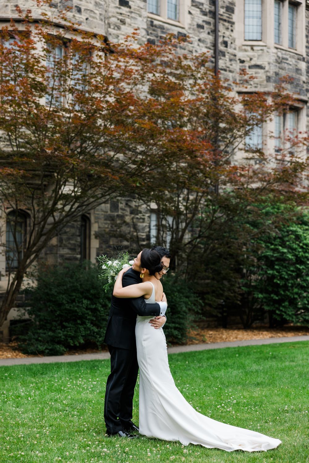 A romantic newlywed couple shares an intimate moment on a green lawn outside of Knox College Chapel.