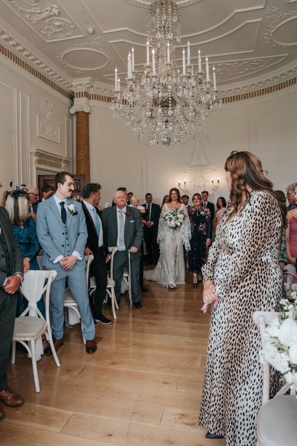 Bride in lace gown walking down the aisle at Rockbeare Manor