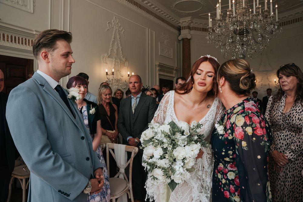 Bride in lace gown walking down the aisle at Rockbeare Manor