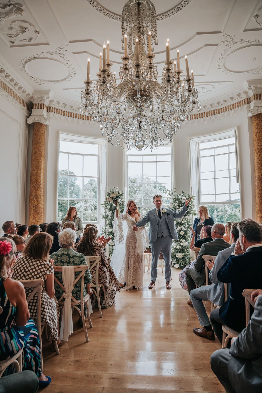 Bride and Grooms first steps as husband and wife after beautiful indoor ceremony at Rockbeare Manor