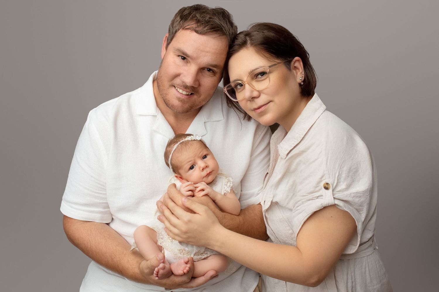 Family and newborn photography Ipswich and Springfield Lakes – parents holding baby in professional studio, affordable portraits for Logan a