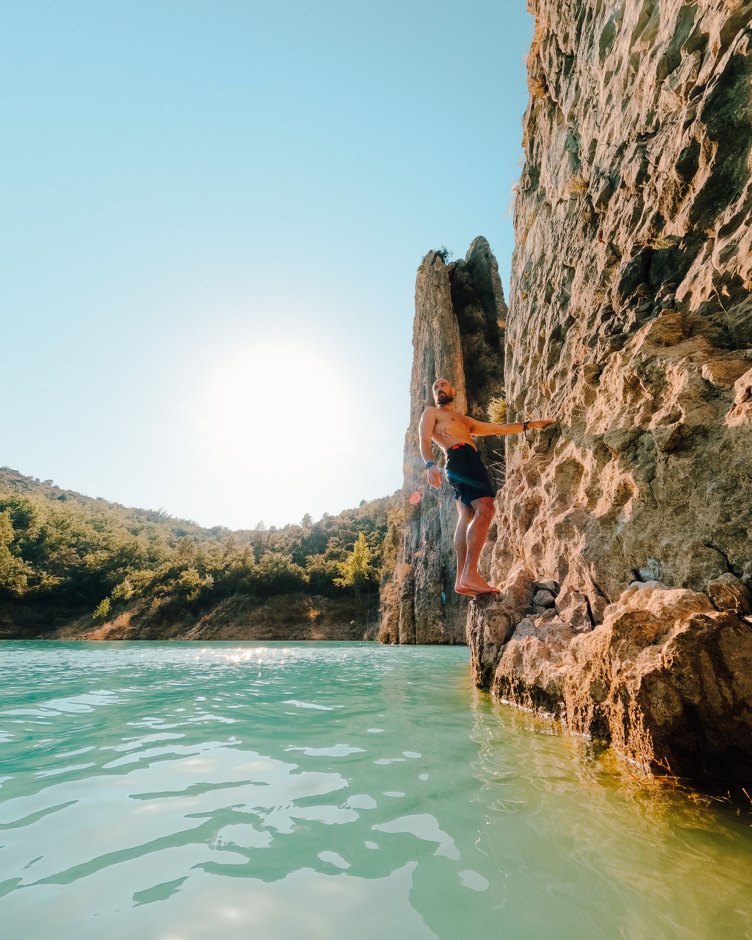 Towering limestone cliffs rising above turquoise waters with dramatic rock formations.