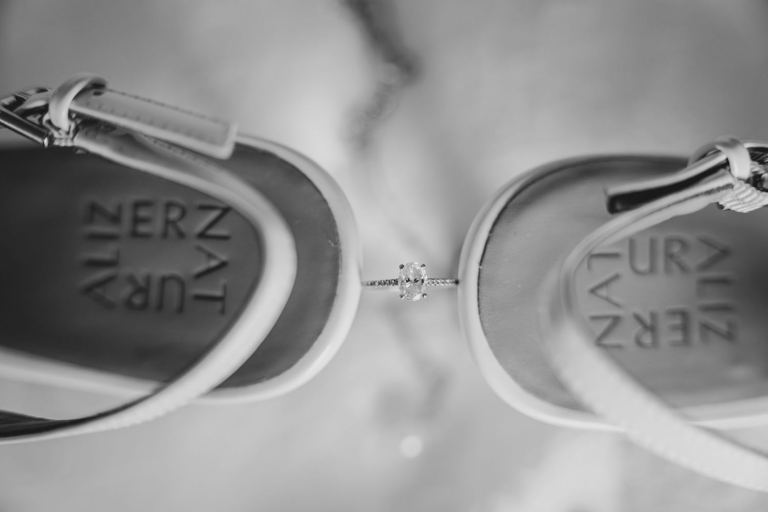 Black and white closeup of inside labels of a pair of shoes showing printed text details.