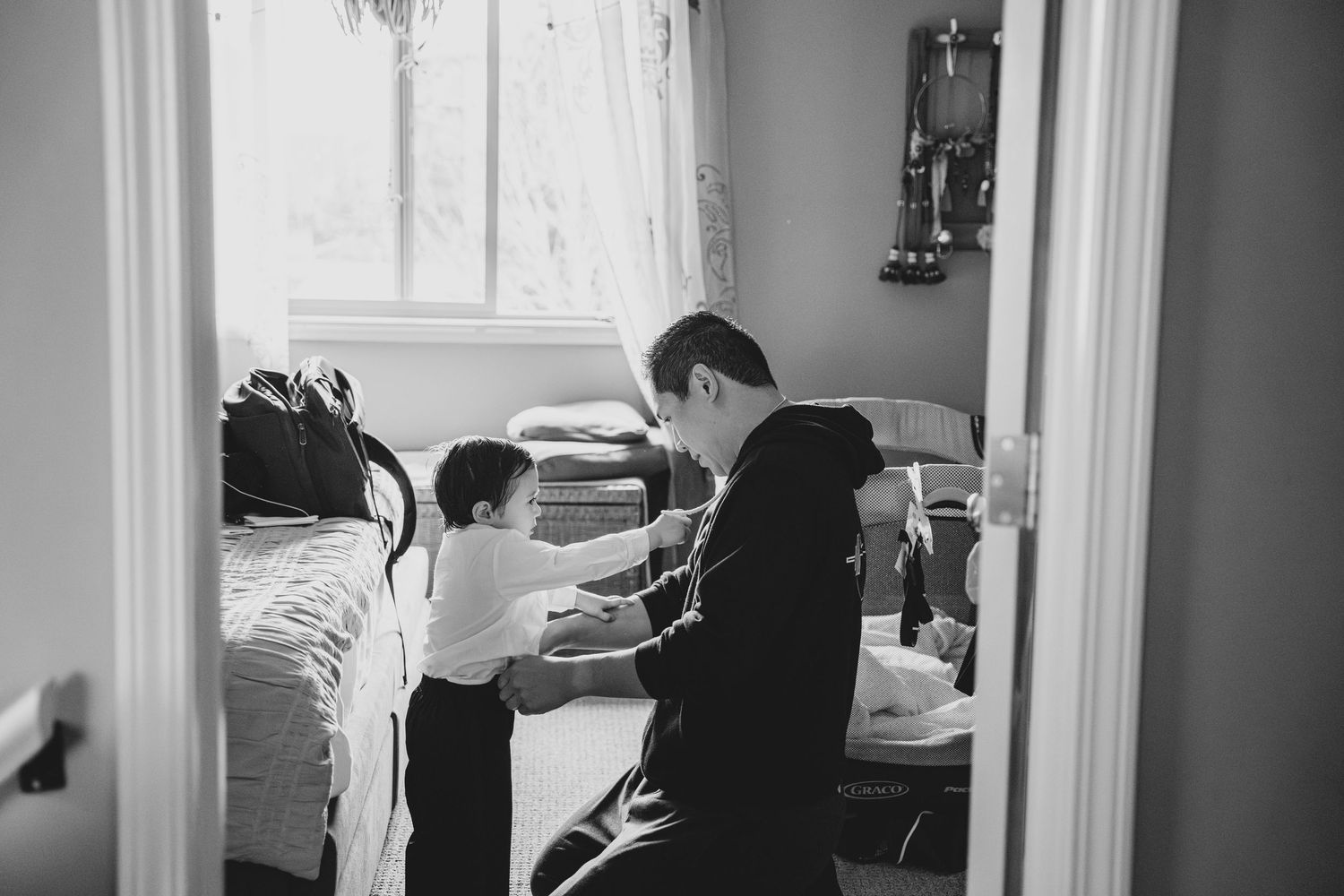 Black and white photo sequence showing someone getting dressed in a suit with jacket, pants and dress shirt.