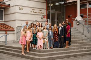 Group photo of people standing on concrete steps outside a building entrance.