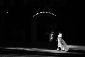 Nine black and white film stills arranged in a row show a haunting theatrical performance on a dark stage.