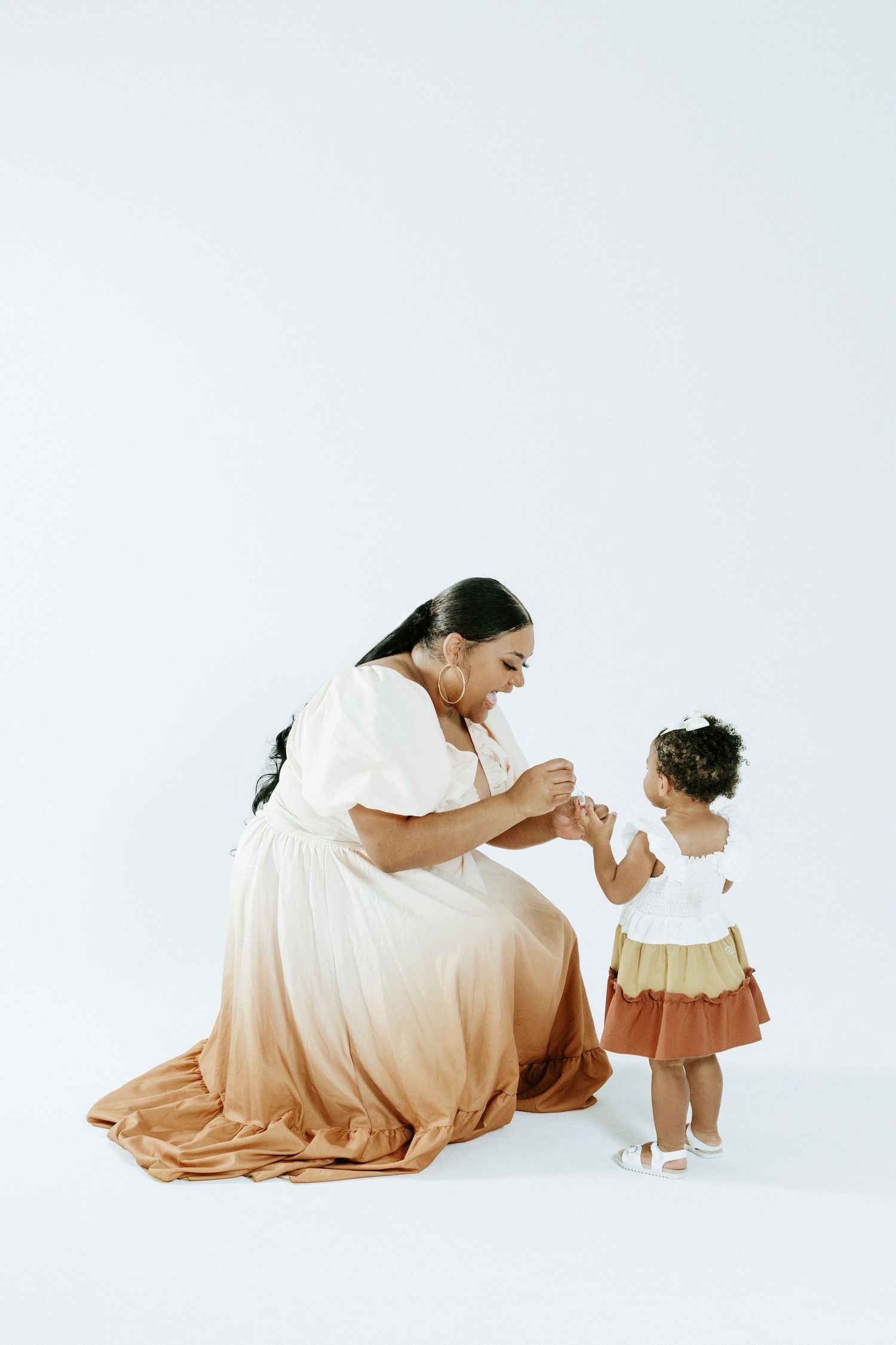 A sweet interaction captured in a minimalist white studio setting.
