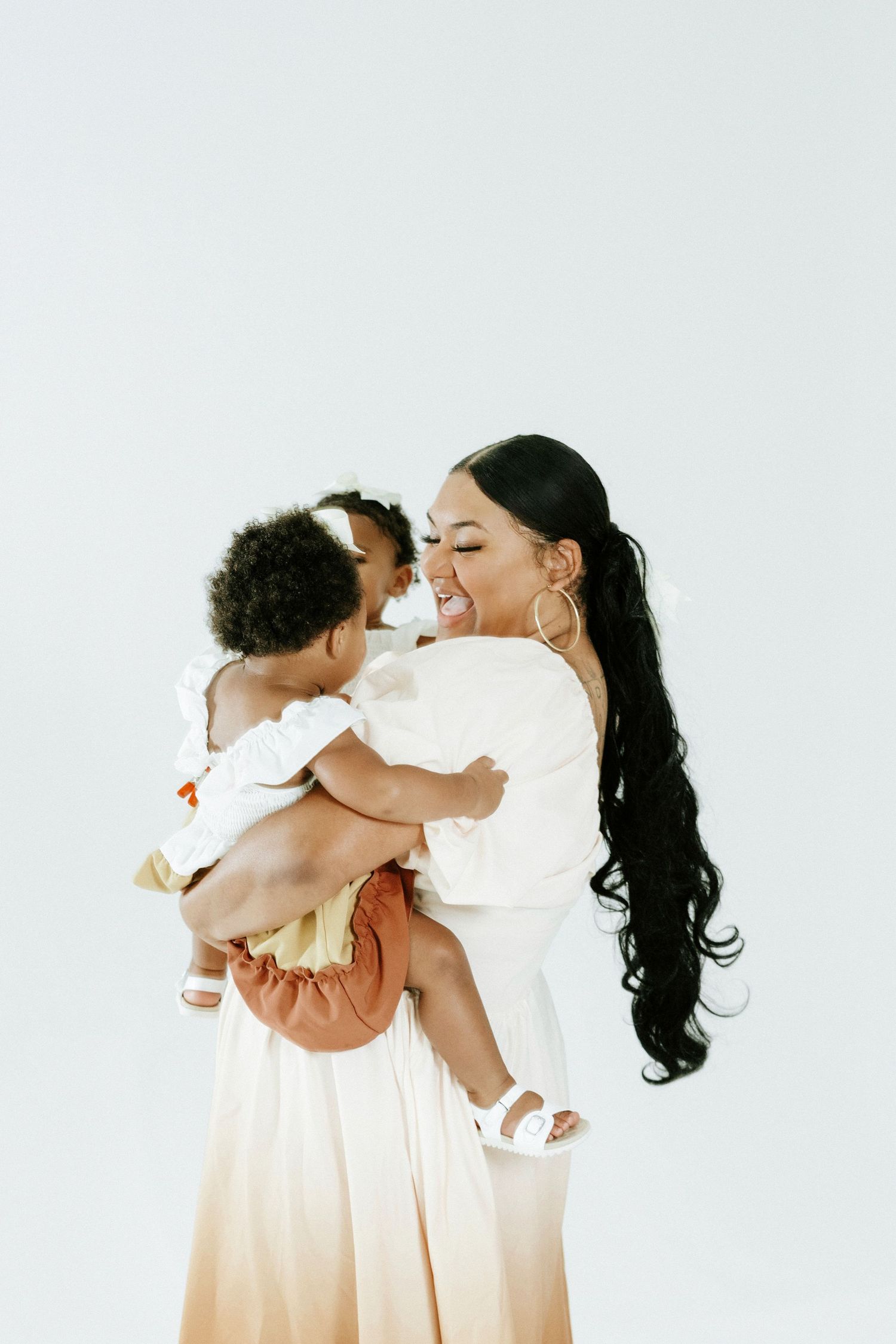 Candid studio portraits featuring coordinated cream and peach colored outfits against a white background.