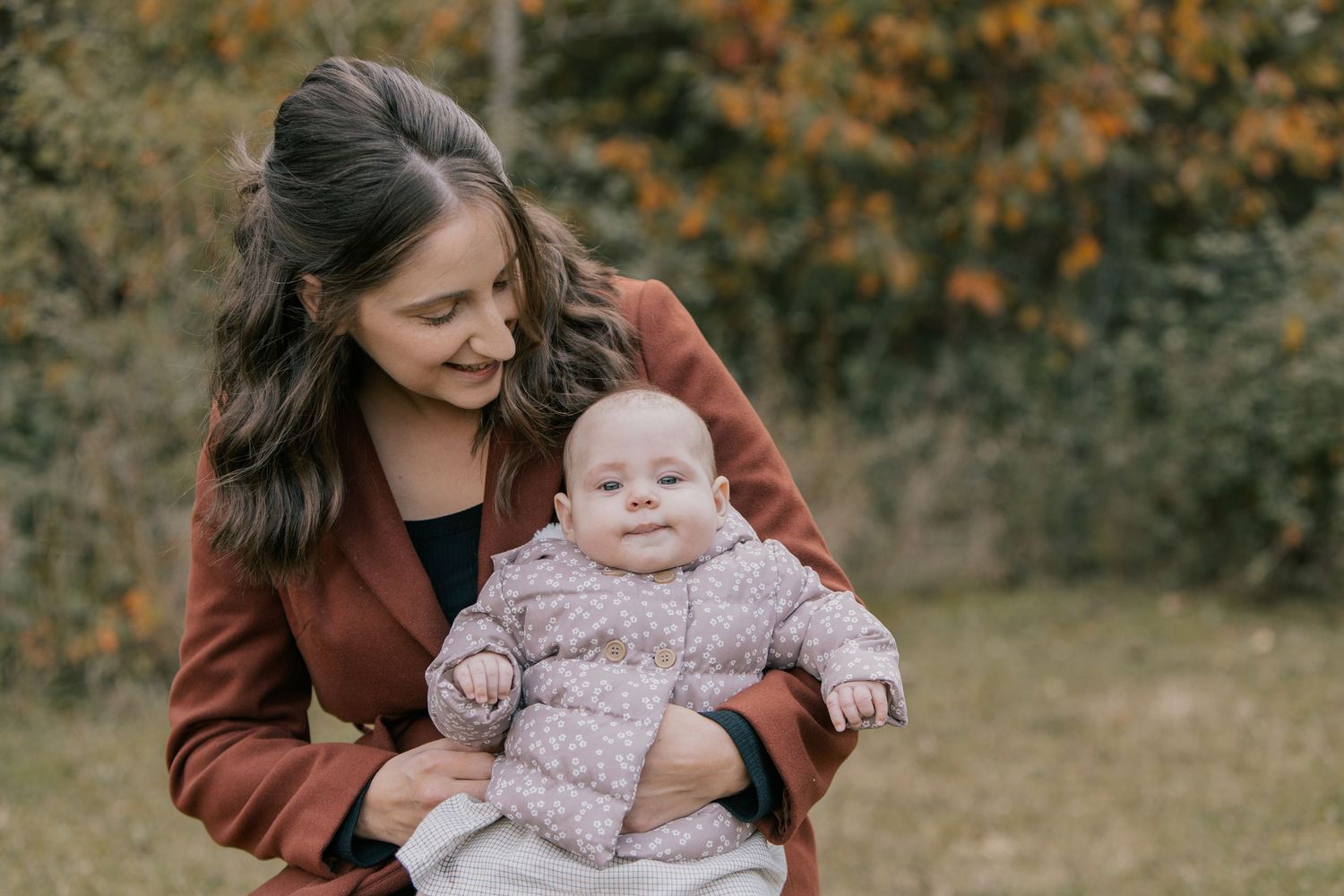 Mum and baby daughter sharing a cuddle in the autumn colours during an autumn mini session in Bedfordshire.