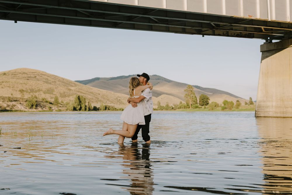 Intimate lakeside photo session with mountain scenery and clear water.