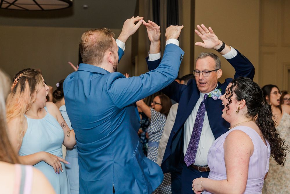 Party guests dancing and celebrating together on a dance floor at a formal event.