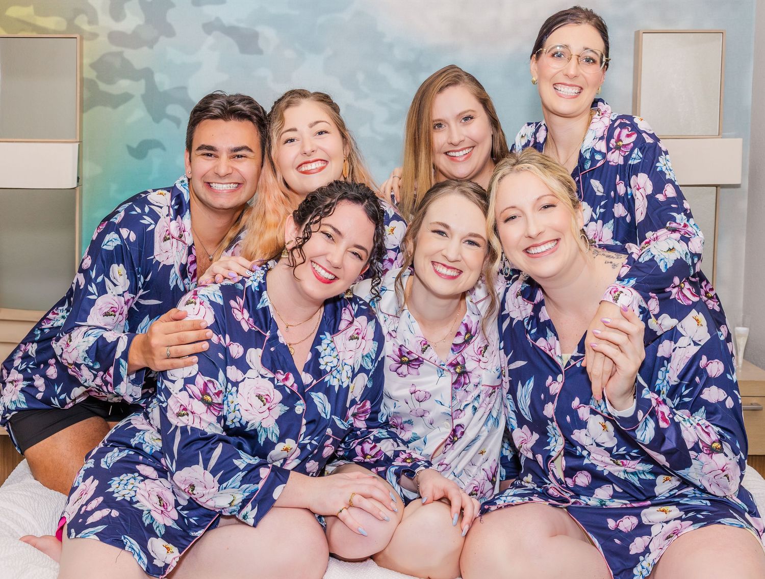 A group wearing matching blue and white floral robes pose together in a joyful candid photo series.