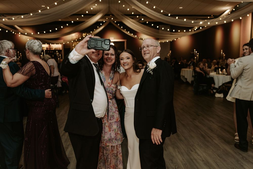 Wedding reception dance floor with string lights and fabric draped ceiling creating a romantic ambiance.