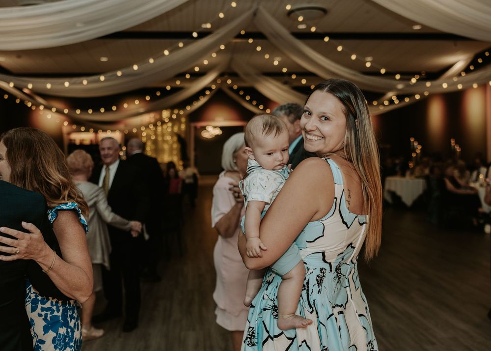 Reception guests dance and celebrate under twinkling lights and draped fabric decor.
