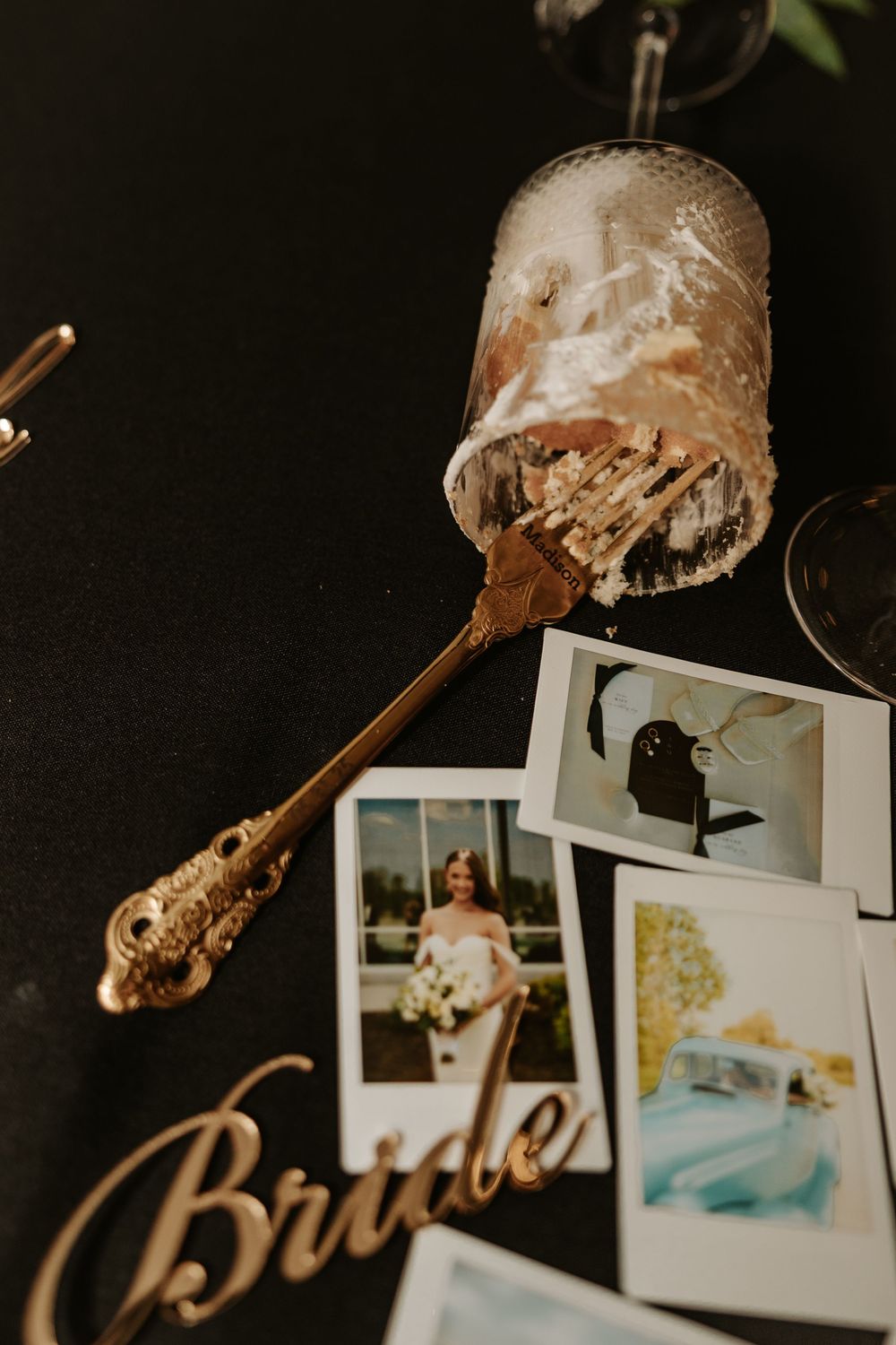 Wedding detail shot of dessert spoon and polaroid photos with gold 'Bride' text decoration.