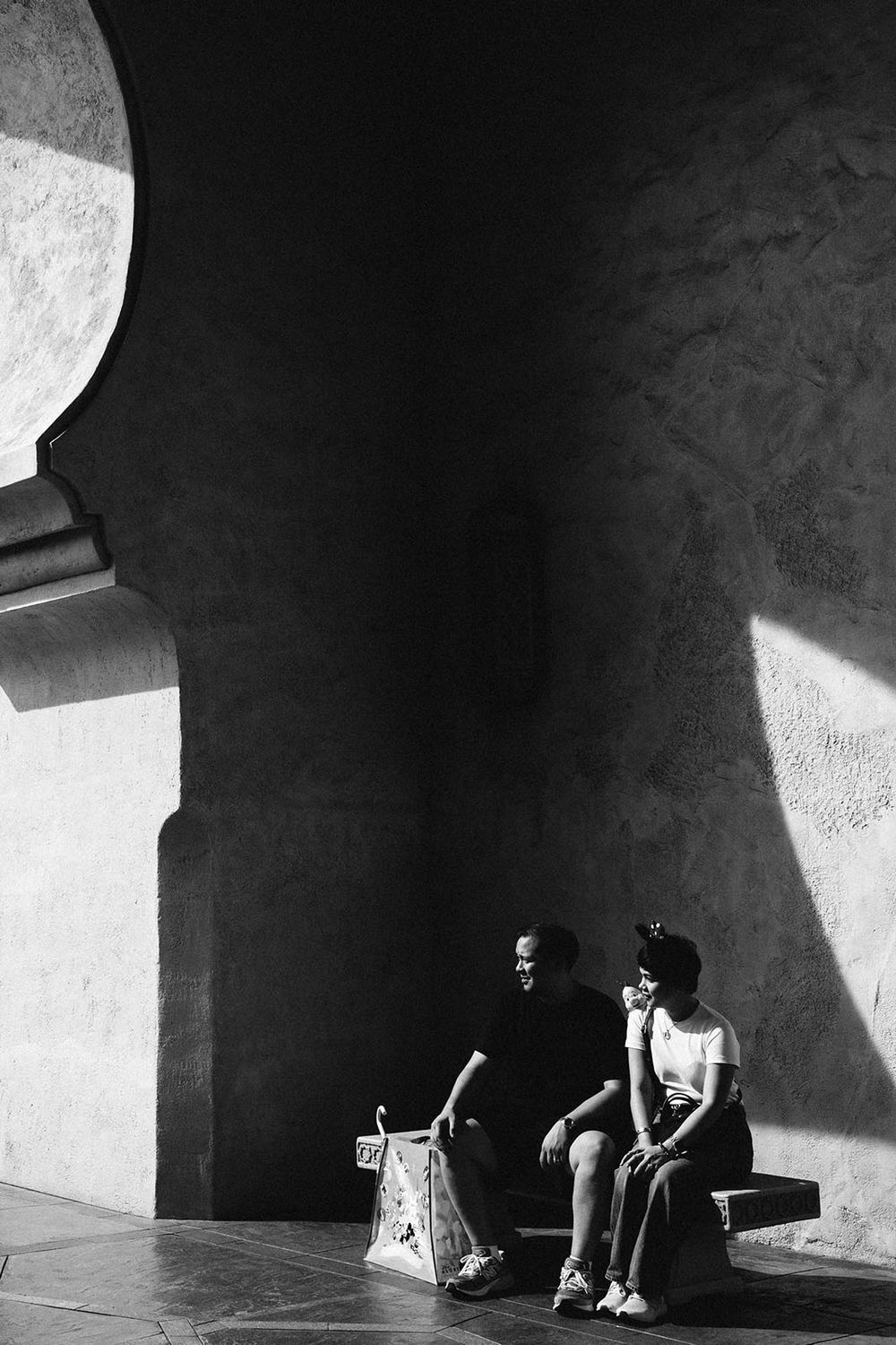 Dramatic black and white photo showing deep shadows and architectural angles with contrasting light and dark elements.
