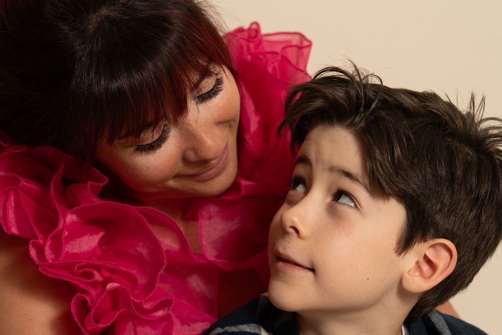 Portrait en gros plan dans une robe à volants rose montrant un moment tendre entre une mère et son fils