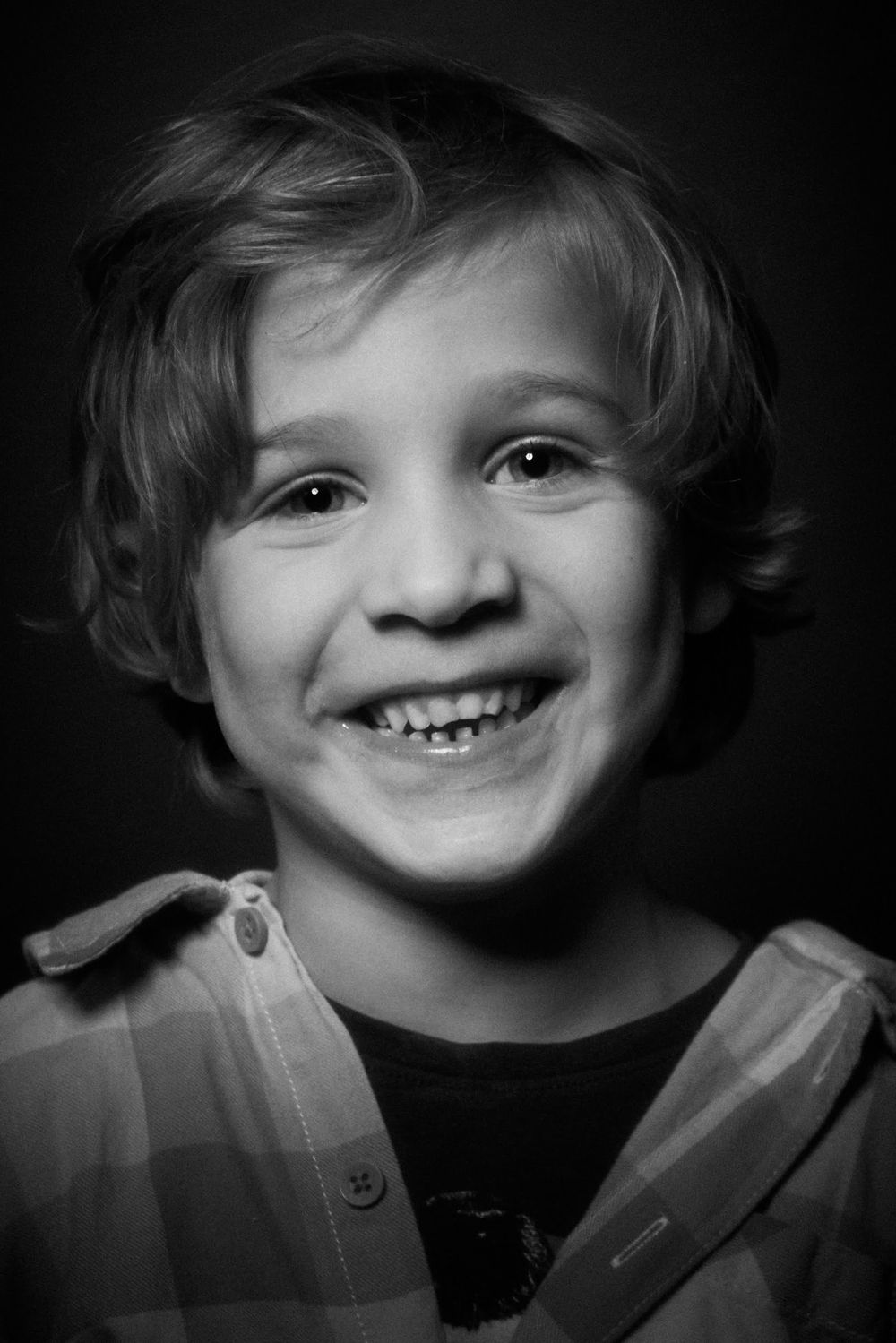 Portrait en noir et blanc montrant une expression joyeuse.