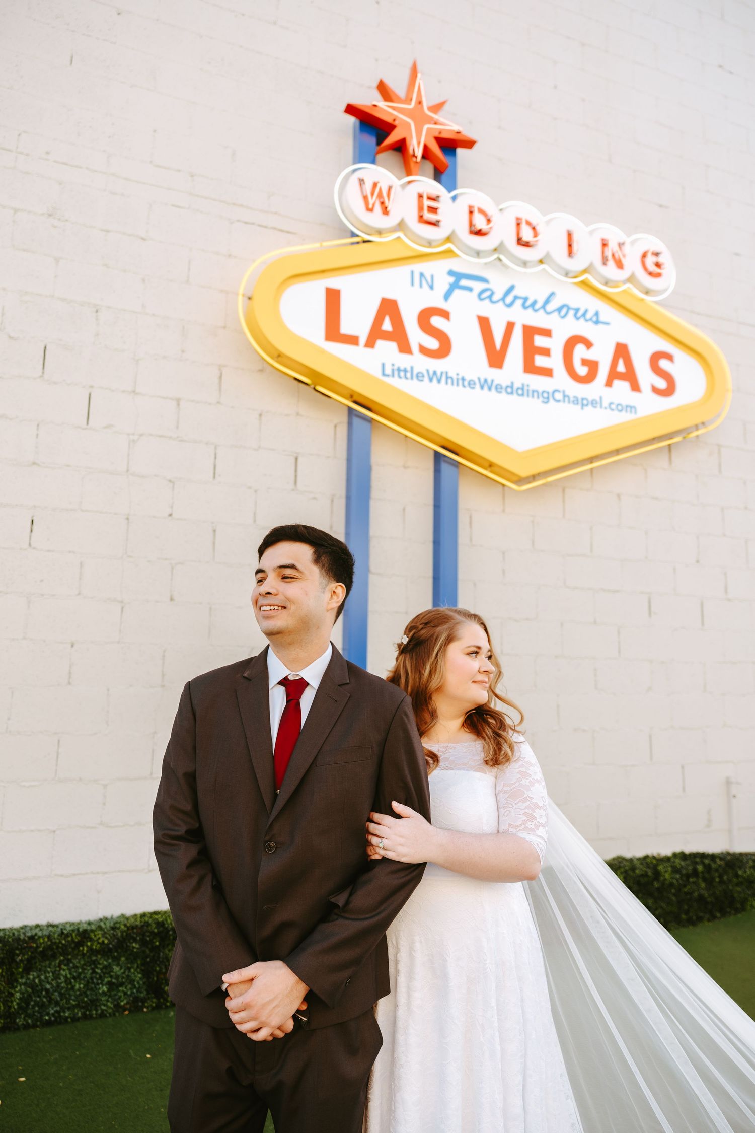 A bride and groom pose beneath the iconic Las Vegas wedding sign.