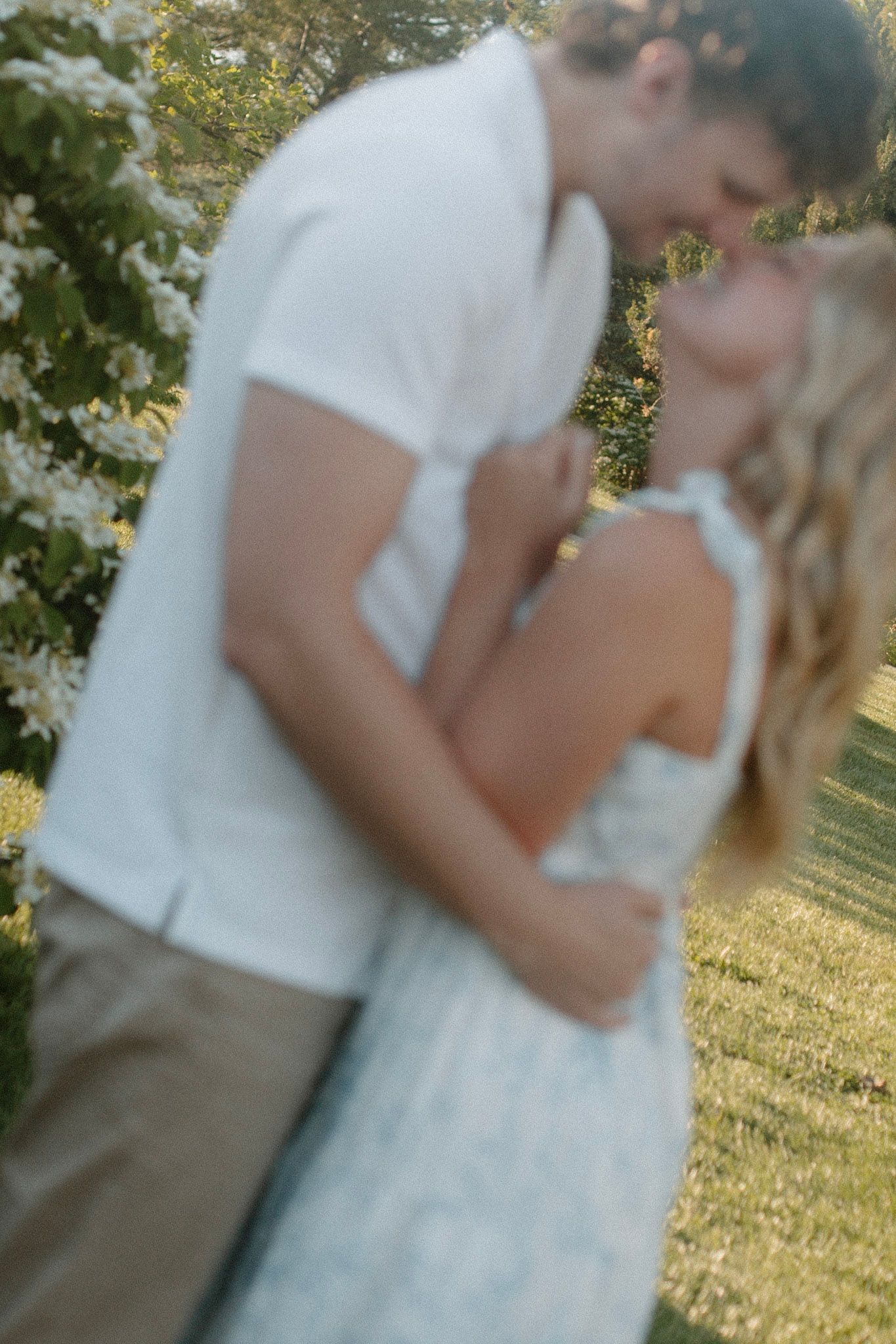 Couple embracing during their engagement session at Millennium Park in Grand Rapids MI and going in for a kiss.