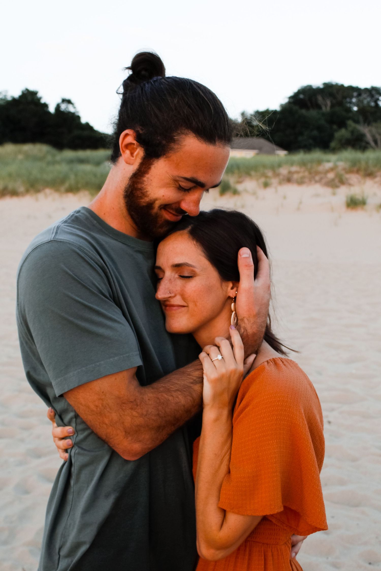 Couple embracing on the beach in Holland, MI during their couple session.
