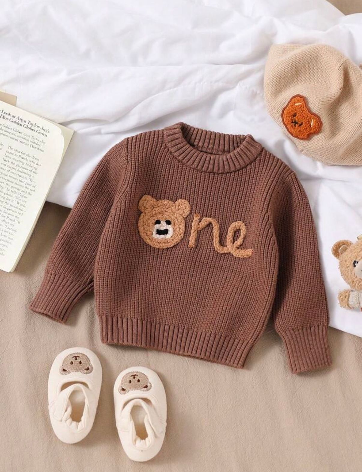 Brown knit baby sweater with cute animal designs and matching booties.