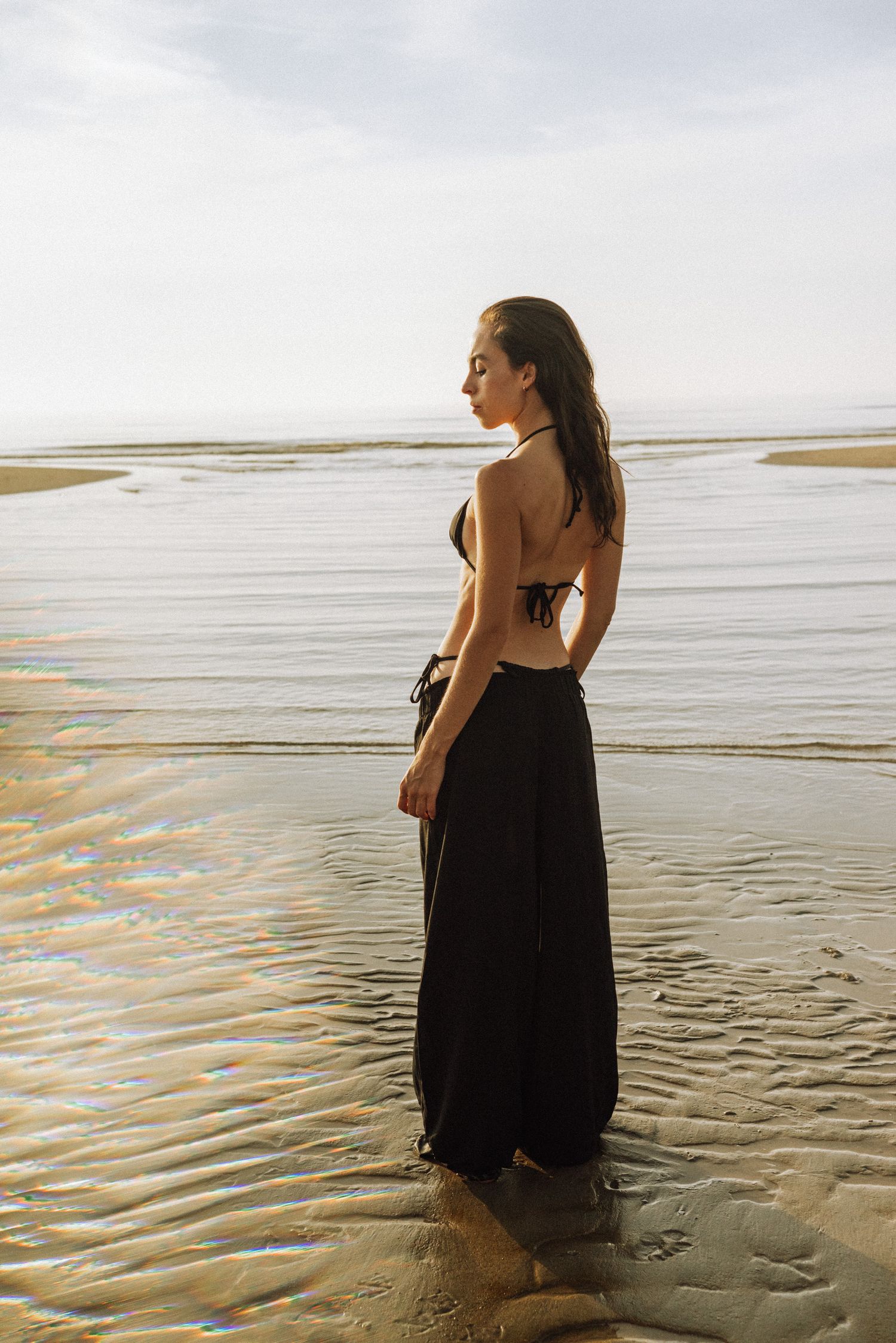 Emotional solo session by the sea in the Netherlands – a woman reconnecting with herself through introspective photography.