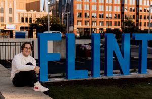 Large blue letters spell out FLINT against an urban backdrop.