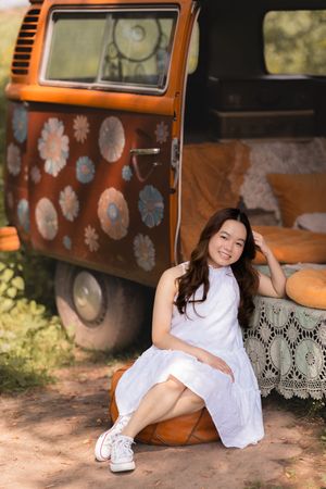 A vintage orange Volkswagen bus with painted flower designs serves as a unique photo setting.