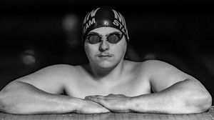 Dramatic black and white photo of swimmer gliding through water during competition.