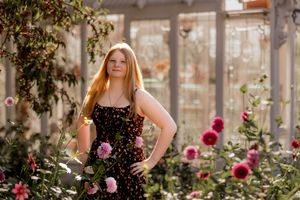 Garden photoshoot featuring roses and flowering plants in the background.