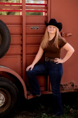 Western-themed portrait session against a red vintage train car.