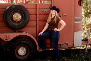 Rustic portraits by a red railroad car with vintage wheels visible.