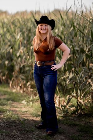 Casual outdoor portraits in western wear with cornfield setting.