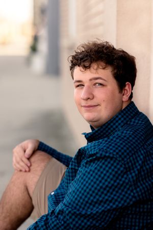 Portrait of someone in blue plaid shirt against soft blurred background.