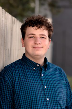 Close-up portrait showing person wearing blue and black gingham pattern shirt.