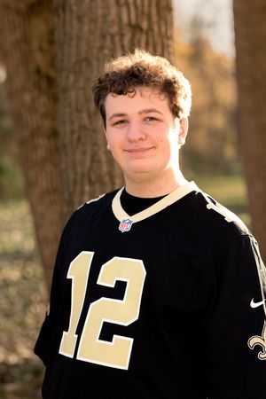 Person wearing black sports jersey with number 12 photographed outdoors.